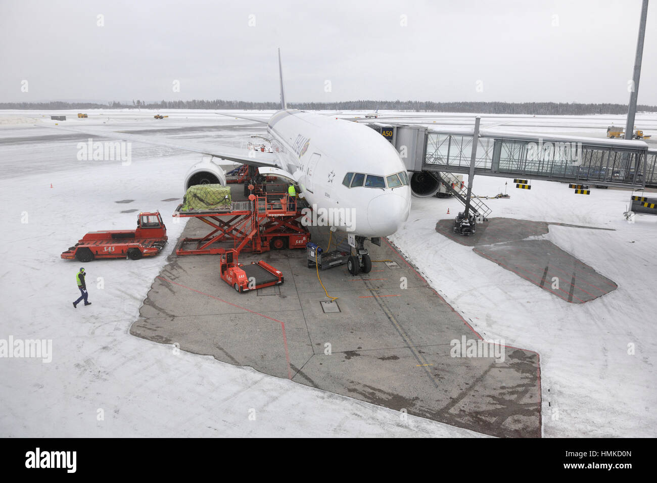 Thai Airways International Boeing 777-200 ER presso il terminale parcheggiato nella neve Foto Stock