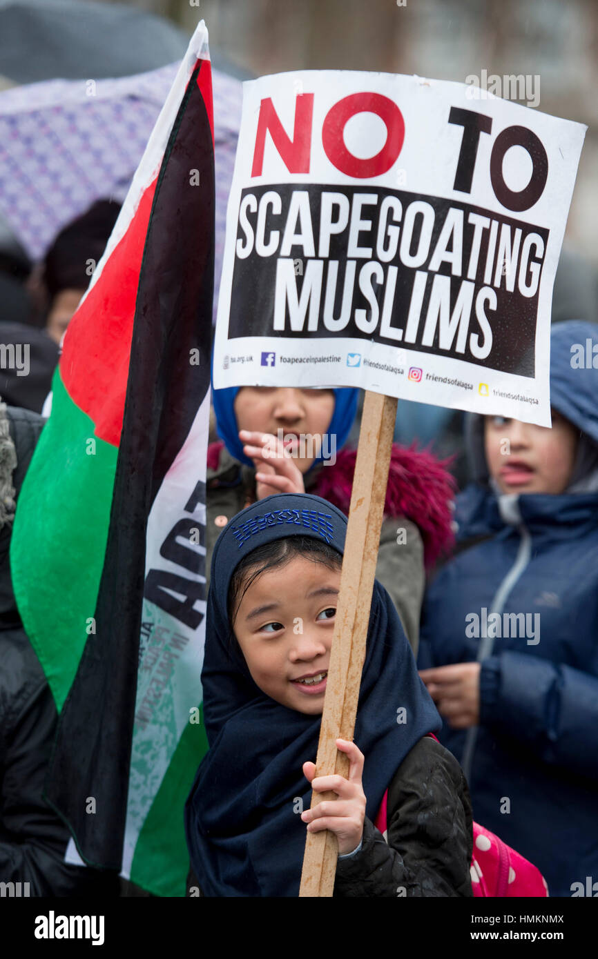 Un bambino tiene un cartello davanti all'Ambasciata degli Stati Uniti a Londra centrale, davanti a una manifestazione di protesta e da marzo a Downing Street, contro il presidente statunitense Donald Trump il divieto di viaggio. Foto Stock