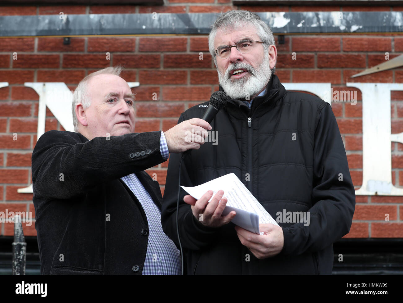 Sinn Fein leader Gerry Adams (destra) parla durante un evento commemorativo a Sinn Fein cade della sede stradale per ricordare tre Partito dei lavoratori che sono stati uccisi in ufficio 25 anni fa. Foto Stock