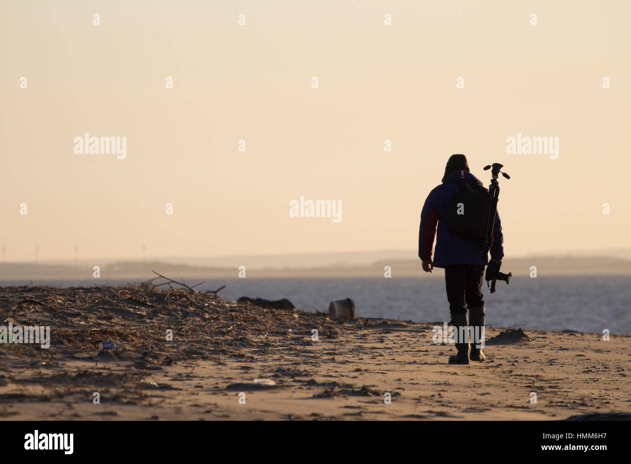 Silhouette di un fotografo di camminare sulla spiaggia al punto di disprezzare, East Yorkshire, Regno Unito Foto Stock