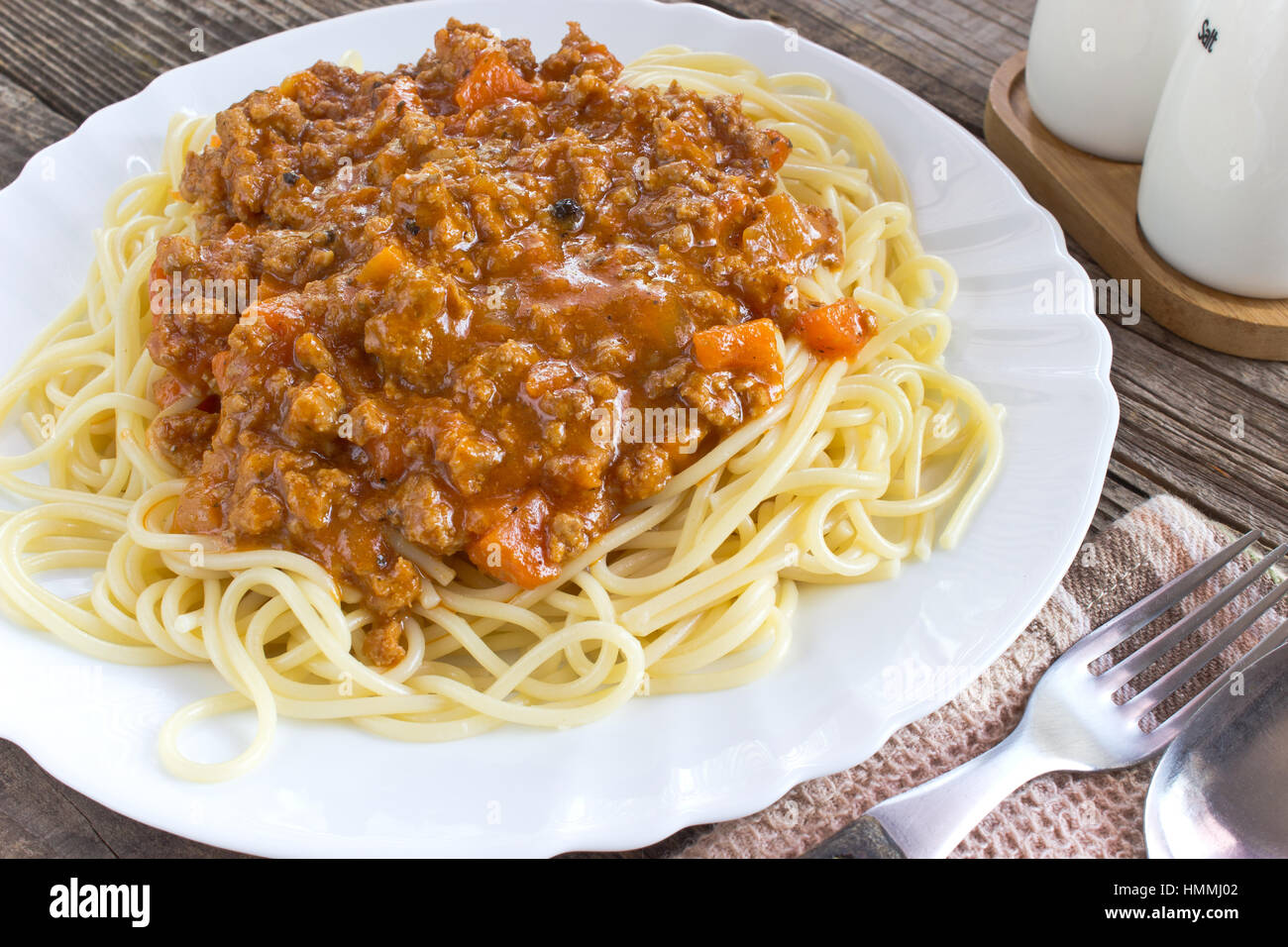 Spaghetti alla bolognese sulla piastra con cucchiaio e forchetta Foto Stock