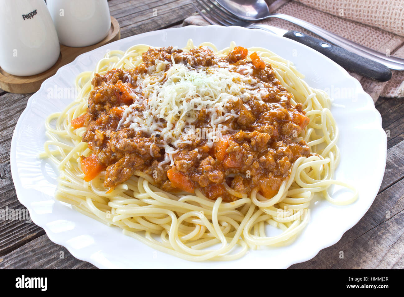 Spaghetti alla bolognese sulla piastra con cucchiaio e forchetta Foto Stock