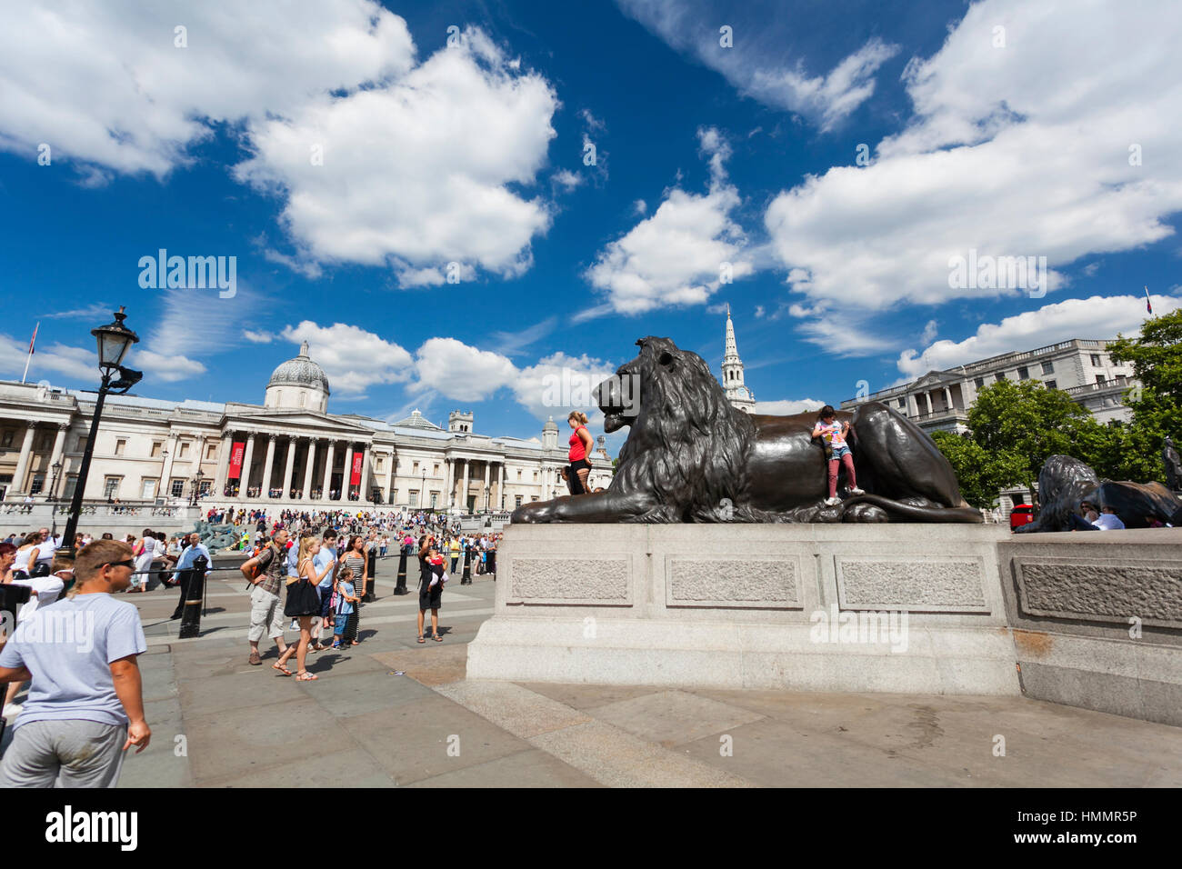 Londra - 20 agosto: Lion statua a Trafalgar Square a Londra con il blu del cielo e turisti di passaggio il 20 agosto, 2013 Foto Stock