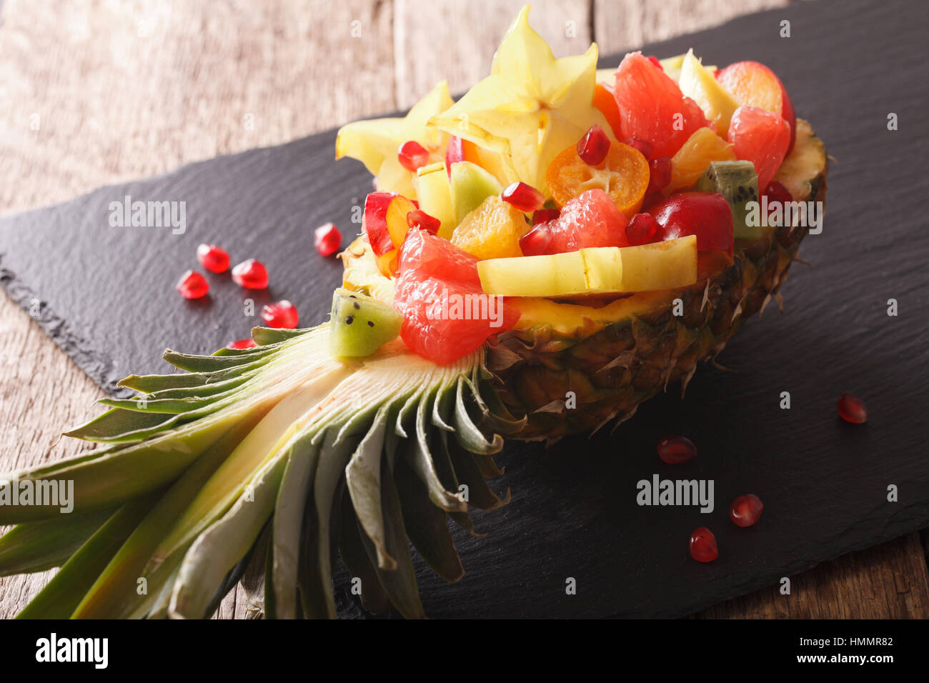 Ananas ripieni con freschi frutti esotici vicino sul tavolo orizzontale. Foto Stock