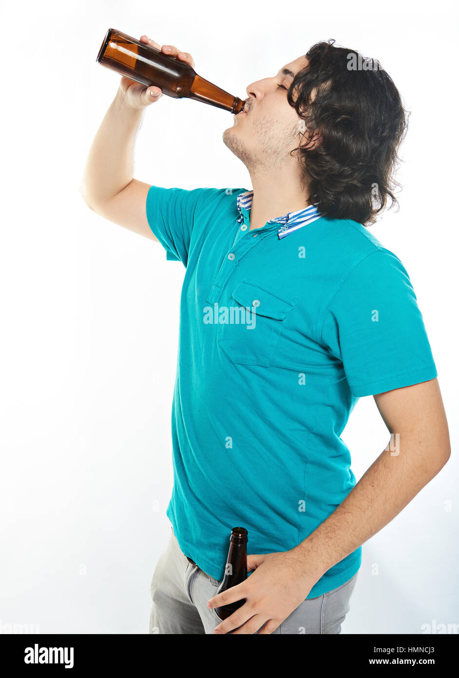 Giovane uomo bere birra forma bottiglia marrone isolato su bianco Foto Stock