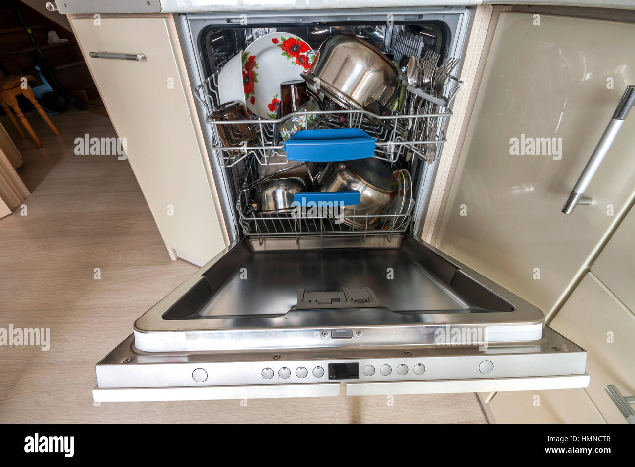 Costruire in lavastoviglie con porta aperta con vetro pulito e piatti nella cucina moderna, il fuoco selettivo Foto Stock