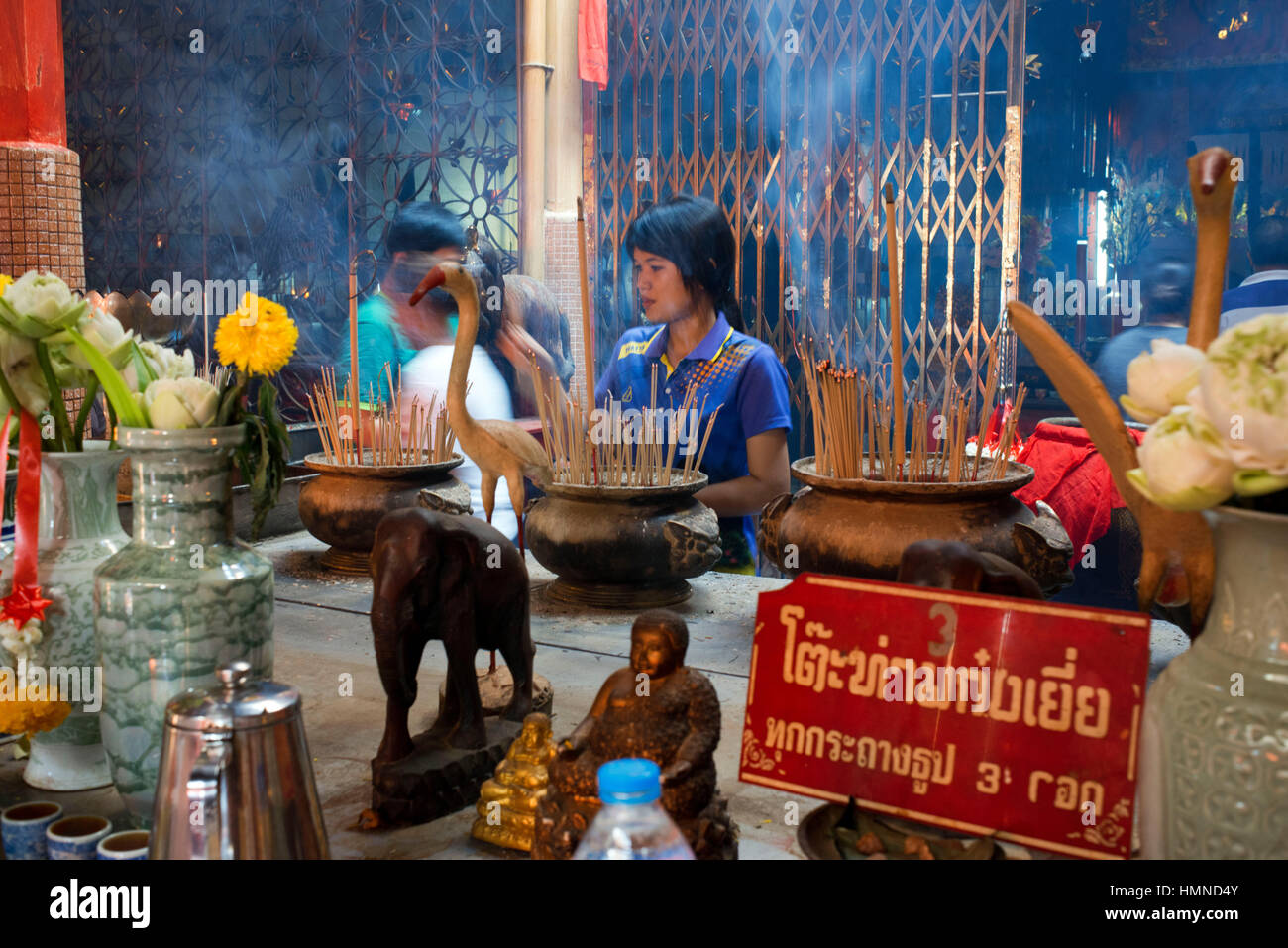 Donna in preghiera tenendo i bastoncini di incenso, tempio complesso in Trang tempio buddista. Trang, chiamato anche Mueang Thap Thiang, è uno del sud pro Foto Stock