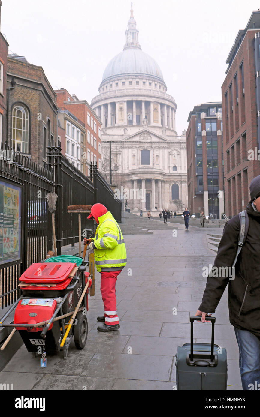 Pulitore di via con dustcart in abbigliamento invernale lavora vicino alla Cattedrale di St Paul nella City di Londra, UK KATHY DEWITT Foto Stock