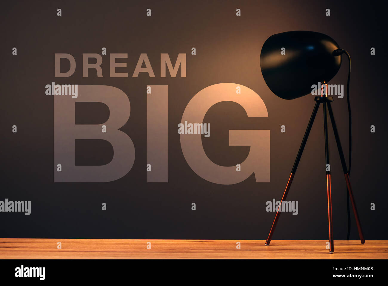 Grande Sogno, concetto aziendale con testo motivazionale sulla parete ufficio illuminato dalla lampada da scrivania Foto Stock