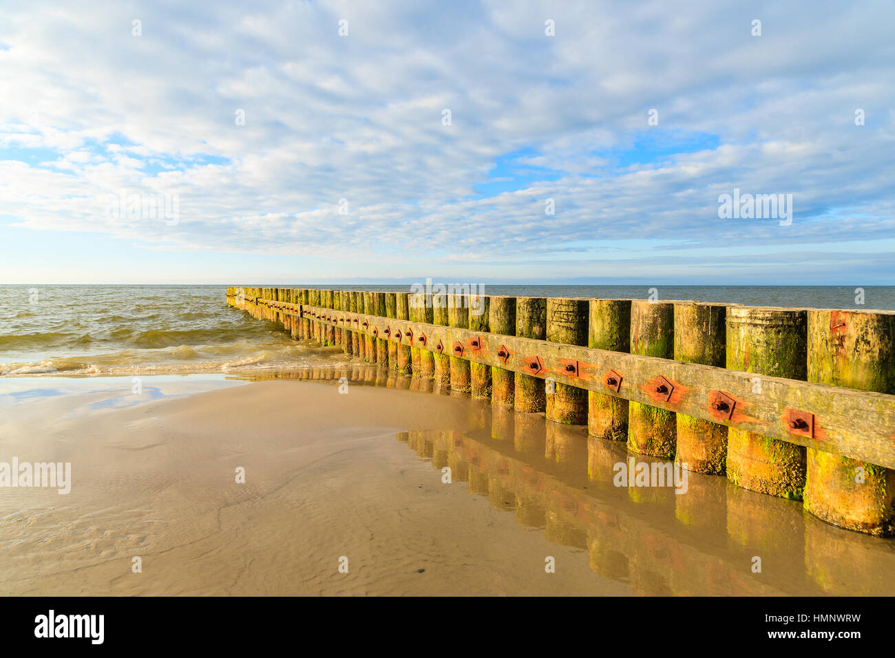 I frangiflutti in legno sulla spiaggia Leba durante la giornata di sole con le nuvole, Mar Baltico, Polonia Foto Stock