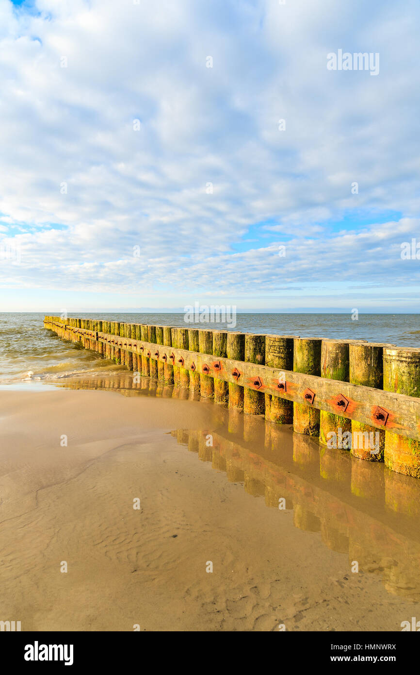 I frangiflutti in legno sulla spiaggia Leba durante la giornata di sole con le nuvole, Mar Baltico, Polonia Foto Stock