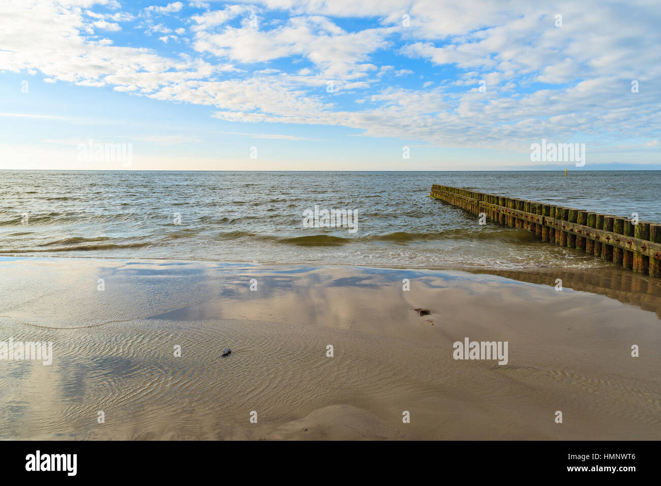I frangiflutti in legno sulla spiaggia Leba durante la giornata di sole con le nuvole, Mar Baltico, Polonia Foto Stock