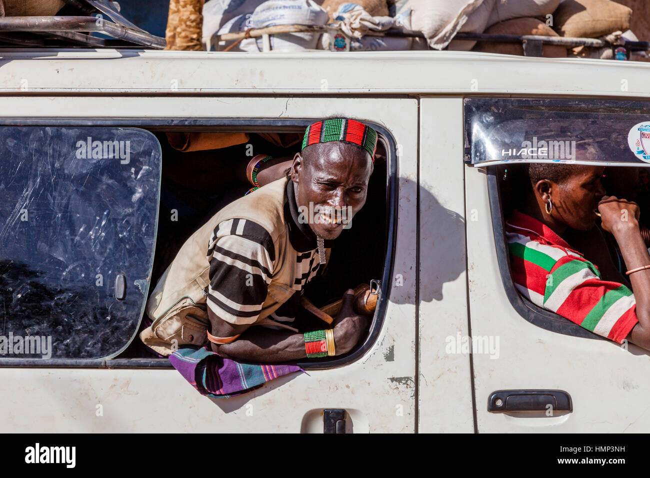 Un Hamer Tribesman si affaccia da una finestra di Minibus nel percorso di ritorno al suo villaggio dopo la Dimeka al mercato del sabato, Dimeka, Valle dell'Omo, Etiopia Foto Stock