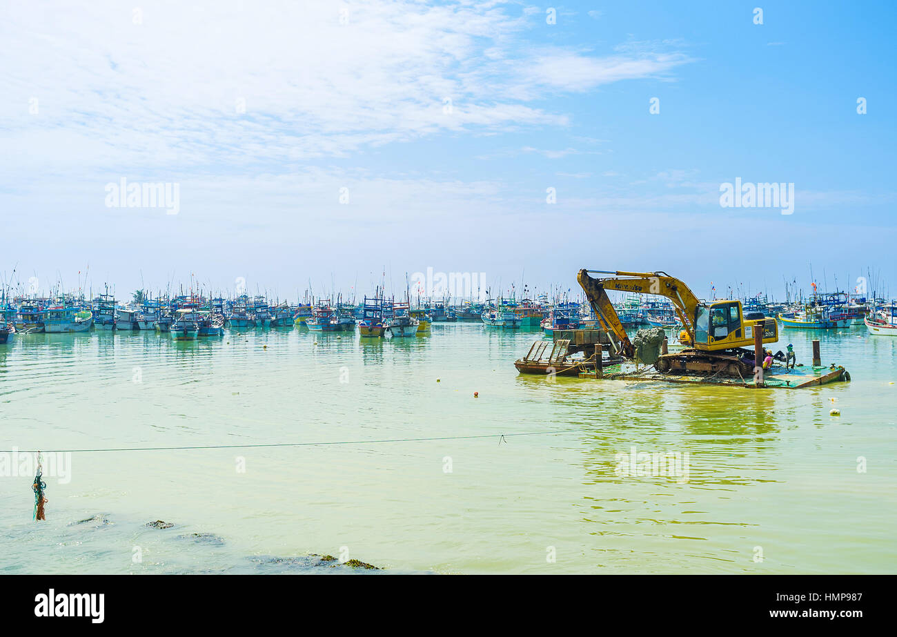 MIRISSA, SRI LANKA - 3 dicembre 2016: l'escavatore anfibio carichi la massa alla floating cargo rimorchio, il 3 dicembre in Mirissa. Foto Stock