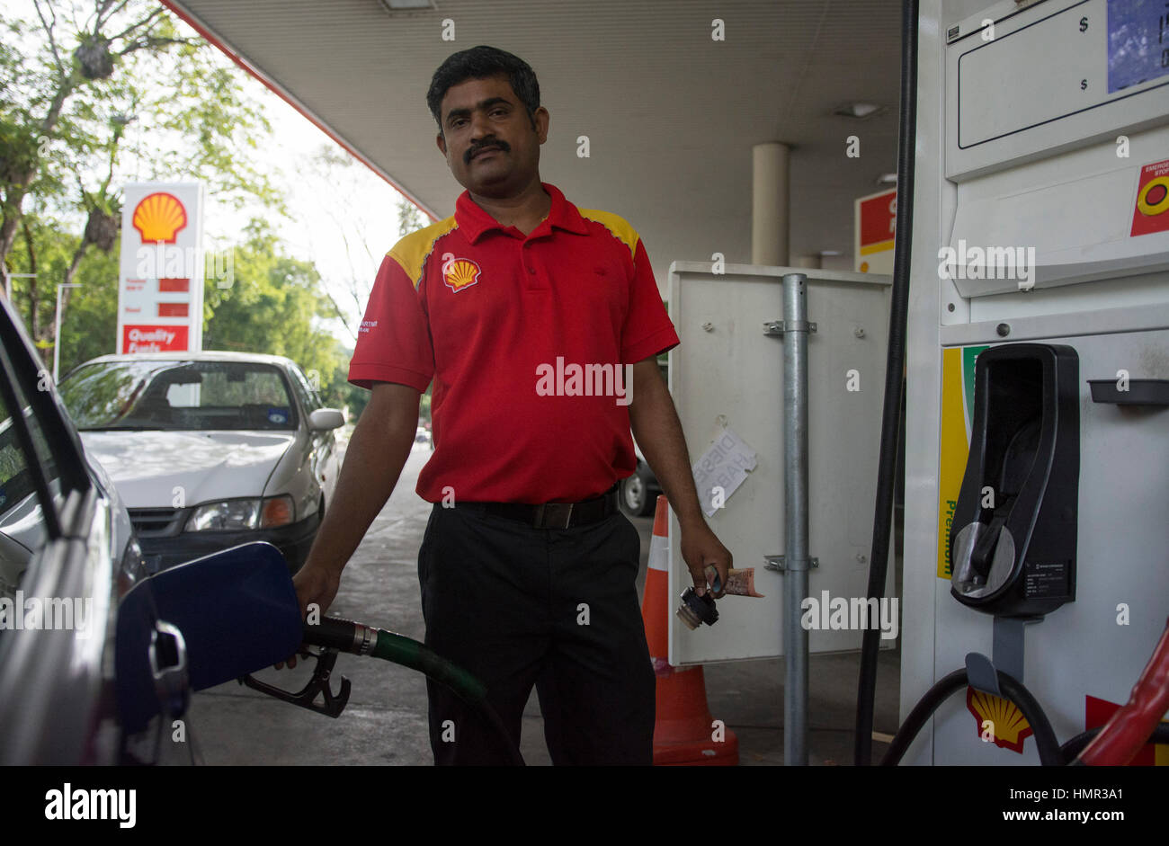Un addetto indiano alla pompa sta riempiendo un'auto con benzina presso un  distributore di benzina Shell nella regione di Seria, Brunei. © Time-Snap  Foto stock - Alamy