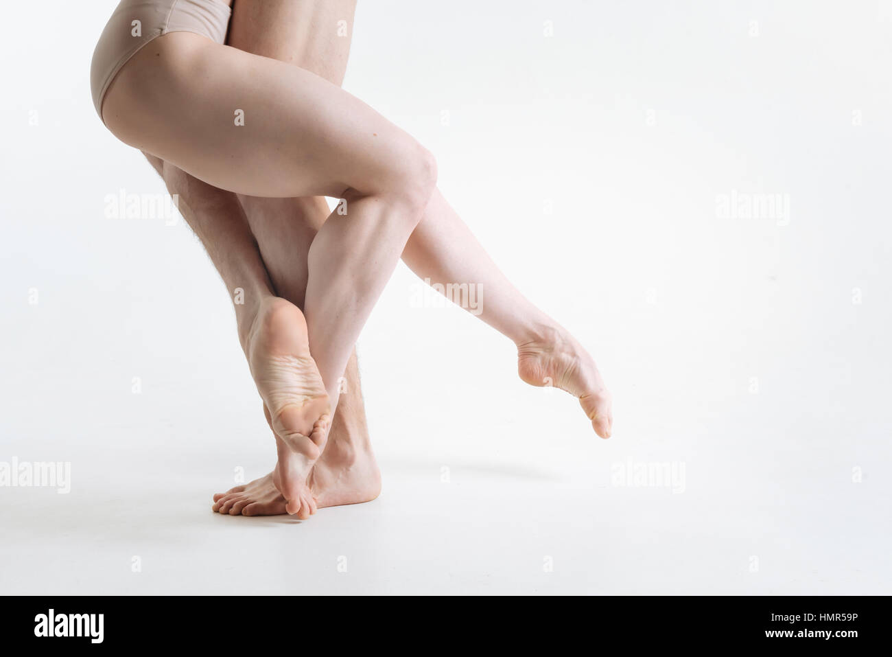 Flessibile gambe di ballerini eseguono nel bianco camera colorata Foto Stock