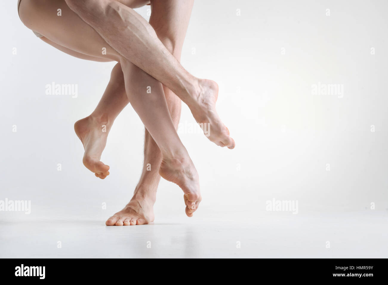 Leggiadre ballerine magistrale gambe eseguendo nel bianco camera colorata Foto Stock