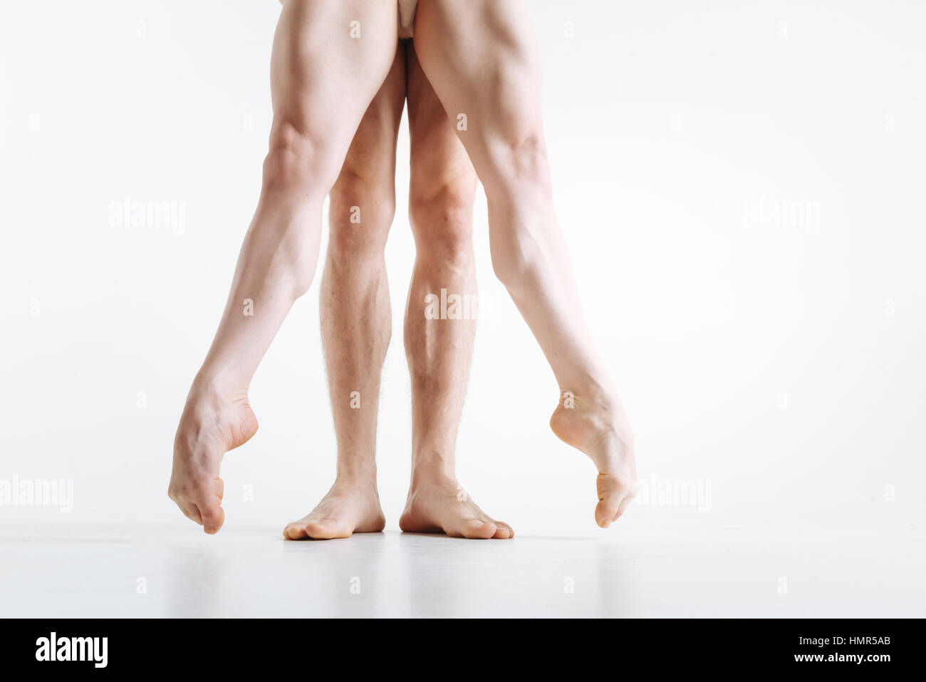 Tensionamento gambe degli atleti di eseguire nel bianco camera colorata Foto Stock