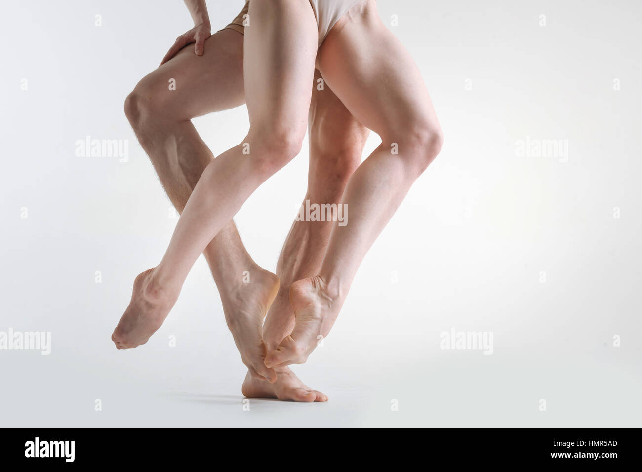 Muscolare delle gambe degli atleti in ballo nel colorato di bianco studio Foto Stock