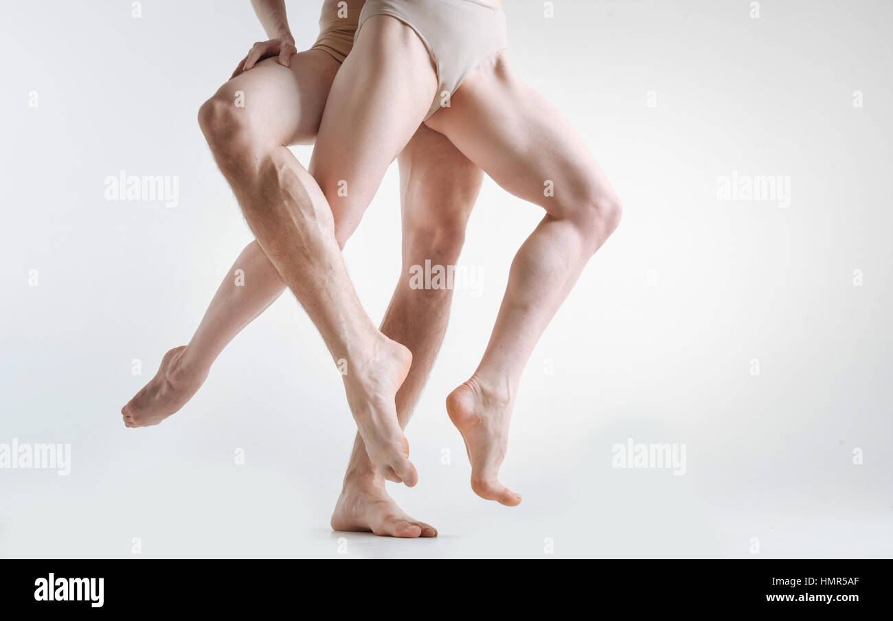 I ginnasti muscolare delle gambe dimostrando eleganza in studio Foto Stock