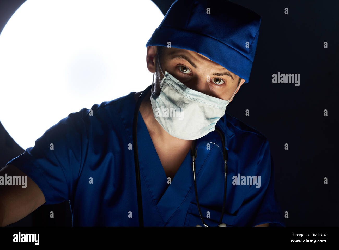 Medico facendo surgeory in ospedale guarda nella telecamera Foto Stock