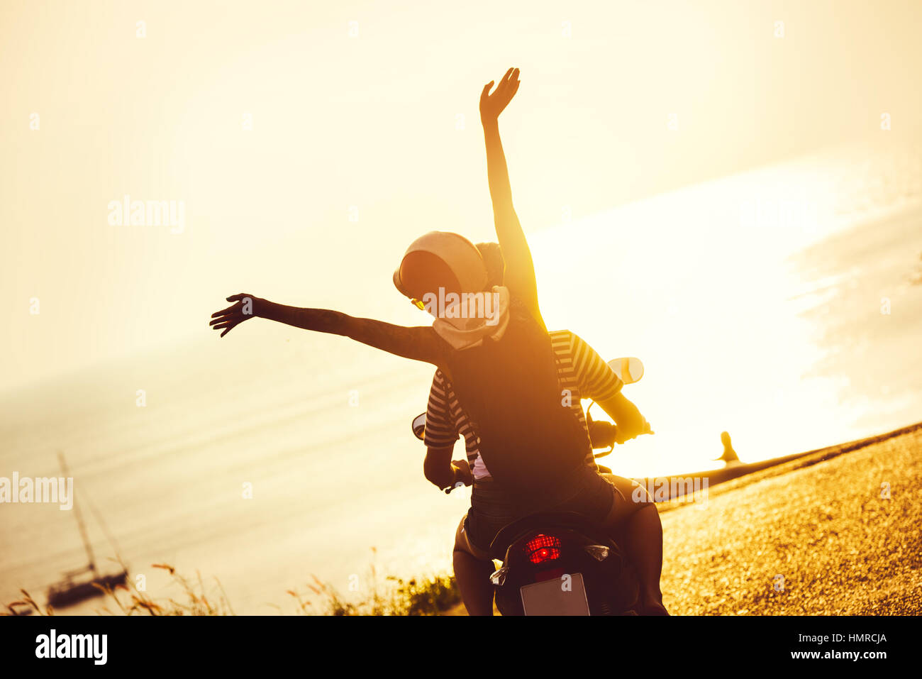 Lifestyle moto giovane viaggi mare al tramonto Foto Stock