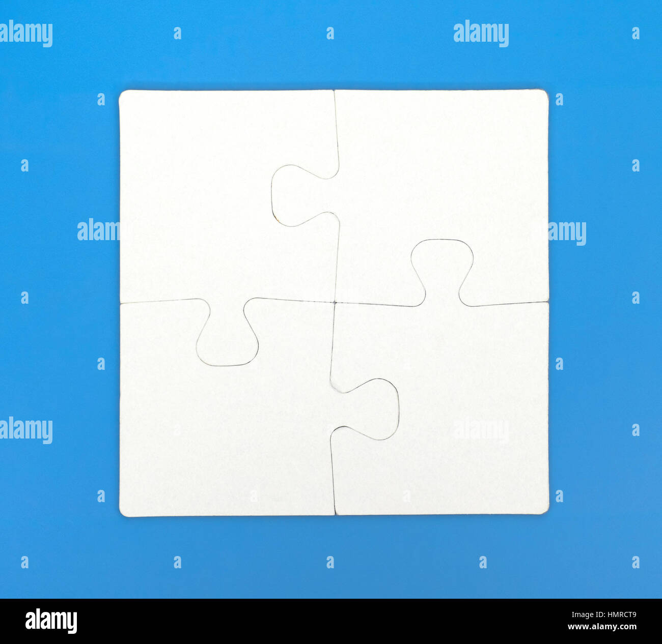 Quattro pezzi di un puzzle sono collegati insieme su sfondo blu. Close-up. Foto Stock