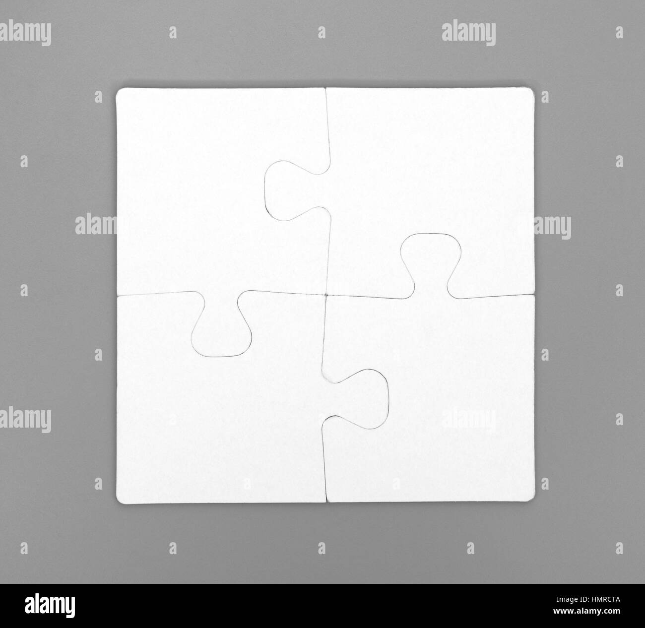 Quattro pezzi di un puzzle sono collegati insieme su sfondo grigio. Close-up. Foto Stock