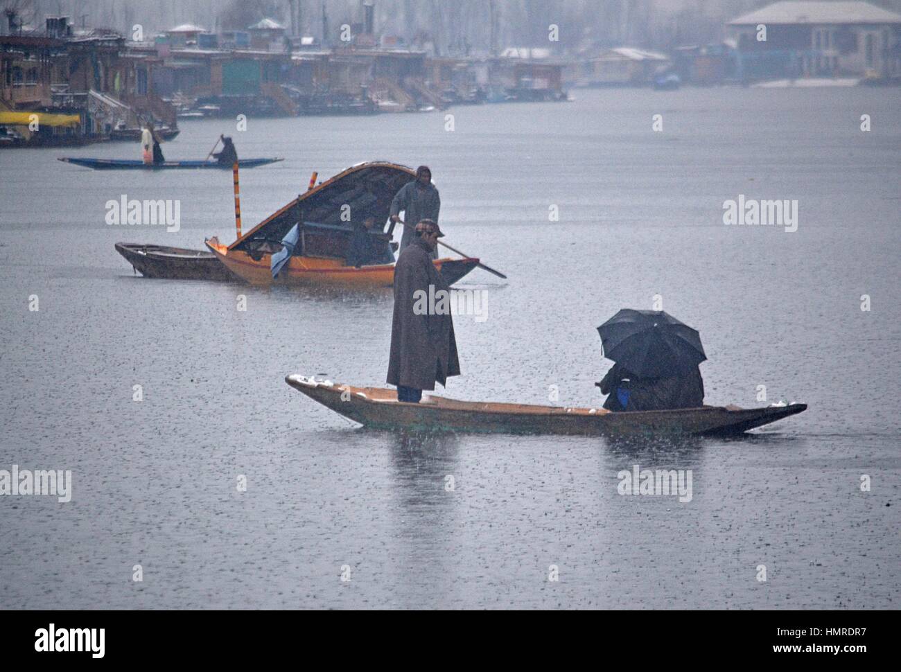 Srinagar, India. 05 feb 2017. Un uomo righe la sua barca come piove a Srinagar la capitale estiva della controllata indiana Kashmir Febbraio 05, 2017. Incantesimo fresco di pioggia e neve ha colpito molte parti del Jammu e Kashmir e la precipitazione è probabilmente destinata a continuare per un altro 48 ore. Il dipartimento di meteorologia, a Srinagar, ha anche rilasciato al bollettino valanghe per alcune aree in Kashmir, il Jammu-Srinagar Autostrada nazionale è stata chiusa per movimenti di veicolare dopo fresche frane in molte aree. Credito: Faisal Khan/Pacific Press/Alamy Live News Foto Stock