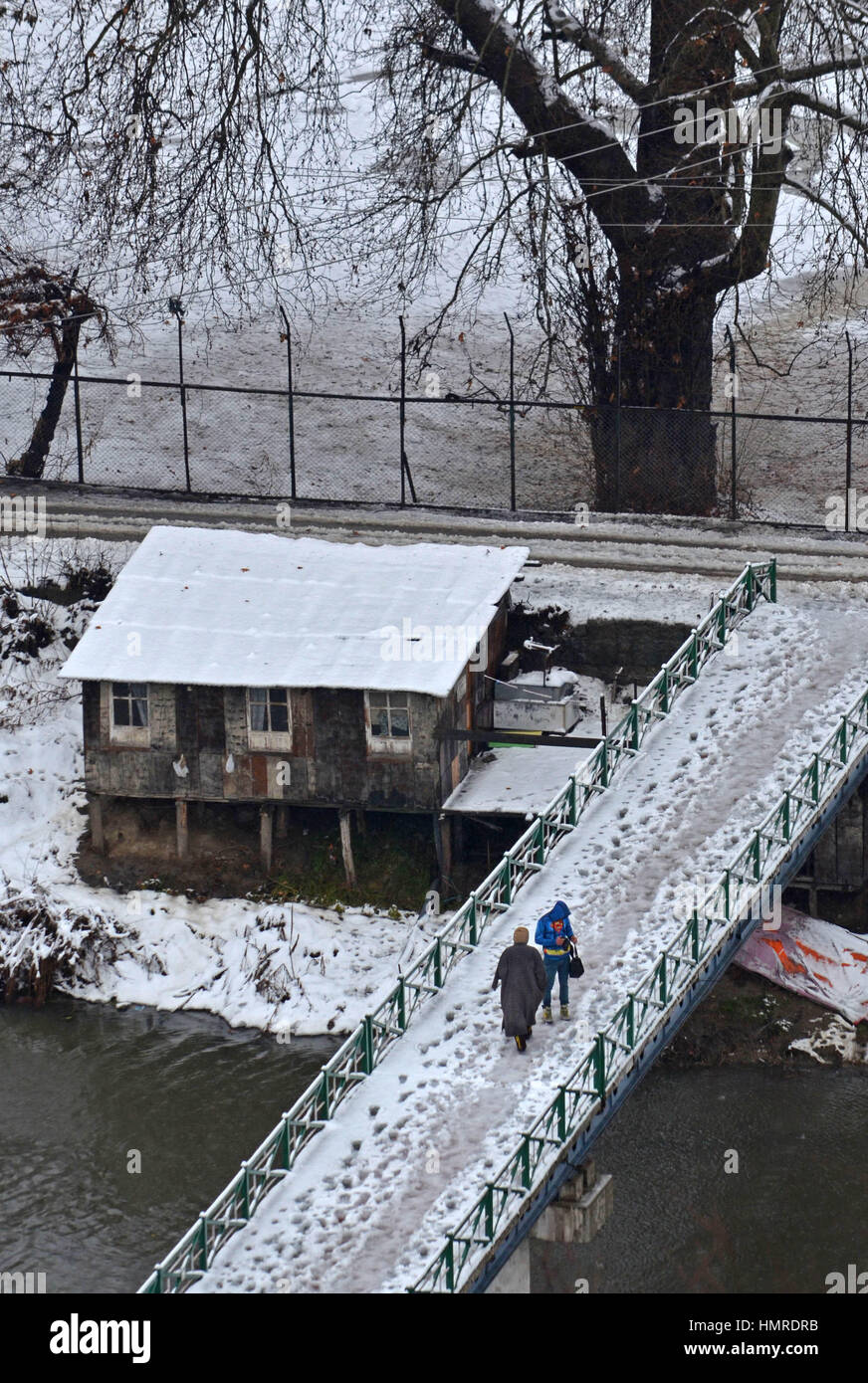 Srinagar, India. 05 feb 2017. Persone attraversano la coperta di neve piedi ponte dopo la nevicata fresca a Srinagar la capitale estiva della controllata indiana Kashmir Febbraio 05, 2017. Incantesimo fresco di pioggia e neve ha colpito molte parti del Jammu e Kashmir e la precipitazione è probabilmente destinata a continuare per un altro 48 ore. Il dipartimento di meteorologia, a Srinagar, ha anche rilasciato al bollettino valanghe per alcune aree in Kashmir, il Jammu-Srinagar Autostrada nazionale è stata chiusa per movimenti di veicolare dopo fresche frane in molte aree. Credito: Faisal Khan/Pacific Press/Alamy Live News Foto Stock