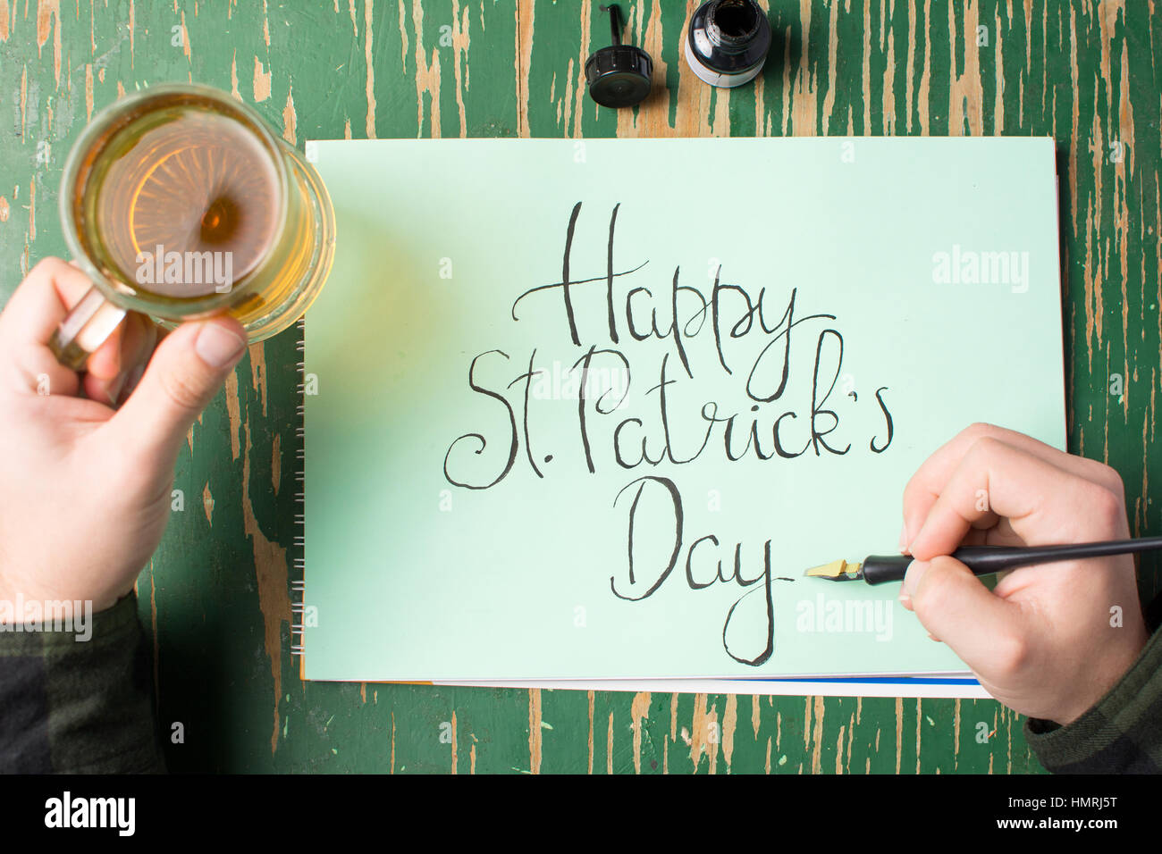 L'uomo con una birra con felice St Patrick giorno scheda di calligrafia Foto Stock