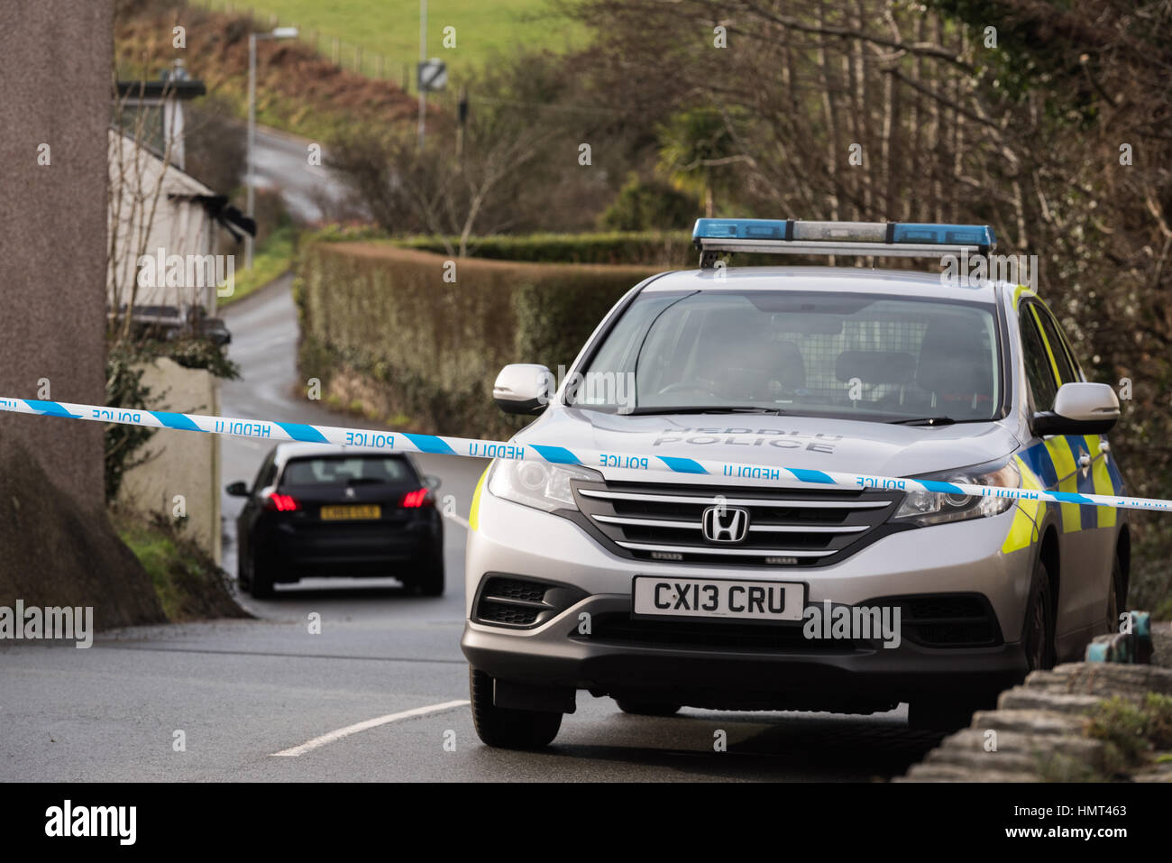 Llanbedrog, Gwynedd, Regno Unito. 5 febbraio 2017. Cordone di polizia la B4413 road per isolare la scena di una fatale mezzanotte riprese di un 18 anno vecchio nel parcheggio della nave Inn nella periferia di Llanbedrog. I team forense indagare la scena mentre la polizia del Galles del Nord, che hanno arrestato 4 uomini, appello per informazioni. Credito: Michael Gibson/Alamy Live News Foto Stock