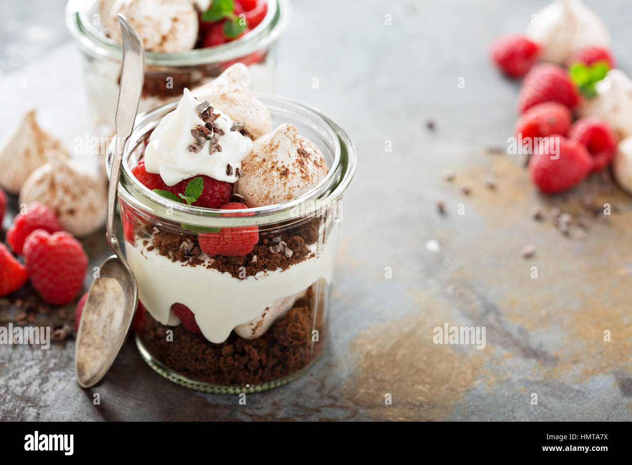 Layered dessert con torta al cioccolato e panna montata e lampone in un vaso Foto Stock