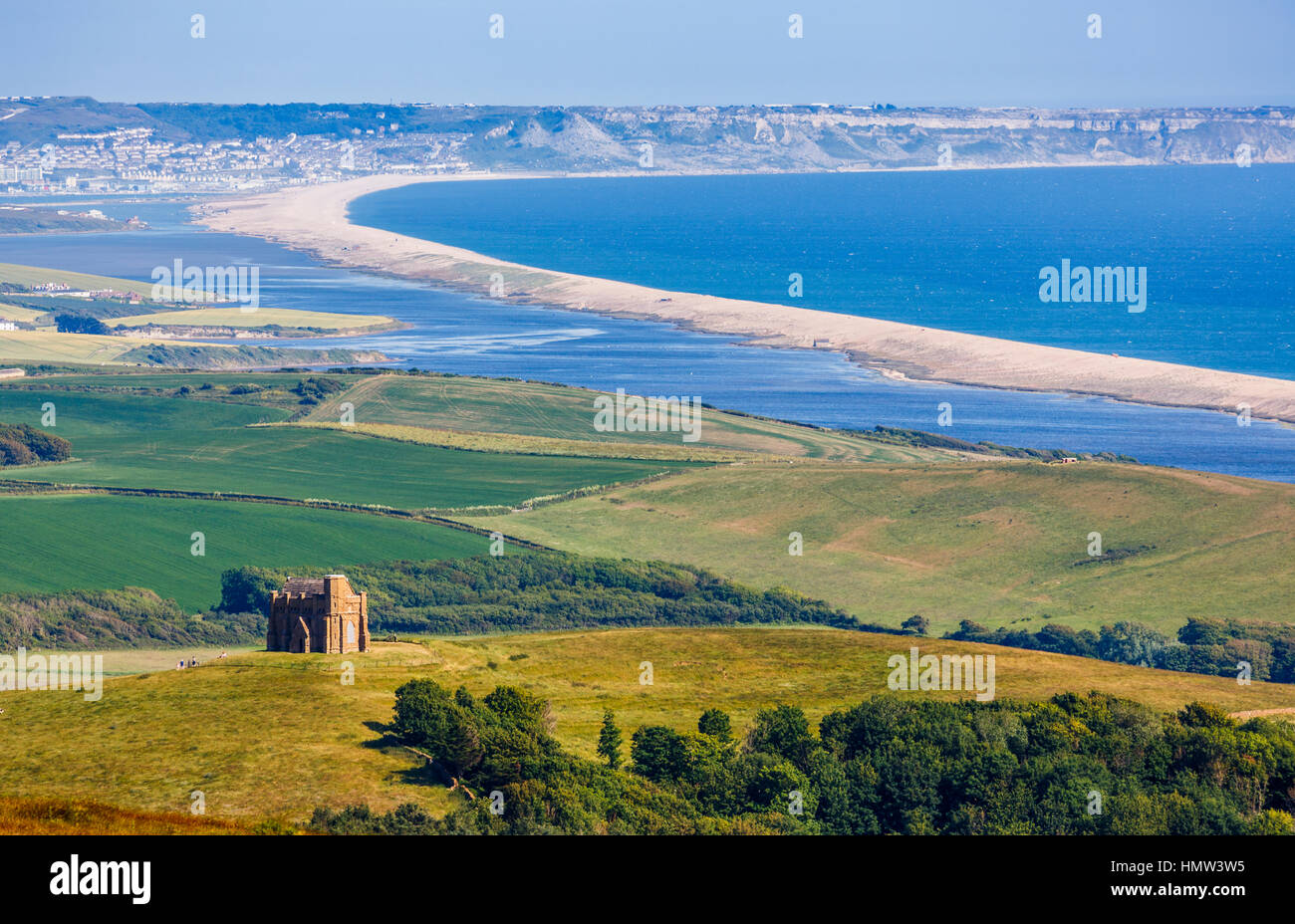 Vista panoramica di Chesil Beach in direzione di Weymouth e l'isola di Portland lungo la costa del Dorset nel sud-ovest dell'Inghilterra in estate con un cielo blu chiaro Foto Stock