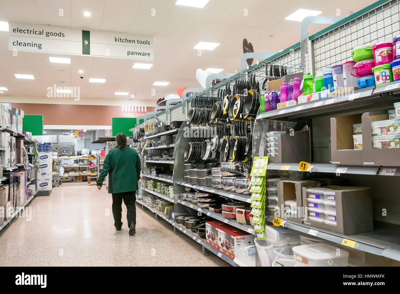 Un membro del personale passeggiate lungo un corridoio all'interno di un supermercato Morrisons. Foto Stock