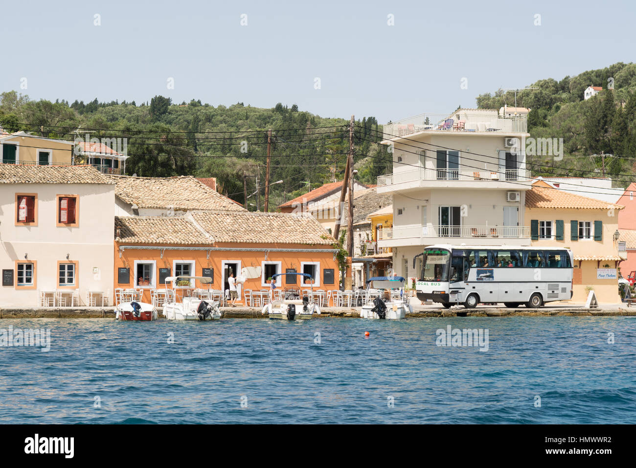 In Pullman La navigazione con cautela la sua strada lungo la strada è molto stretta nella piccola pesca greca e villaggio vacanze di Loggos sulla piccola isola di Paxos Foto Stock