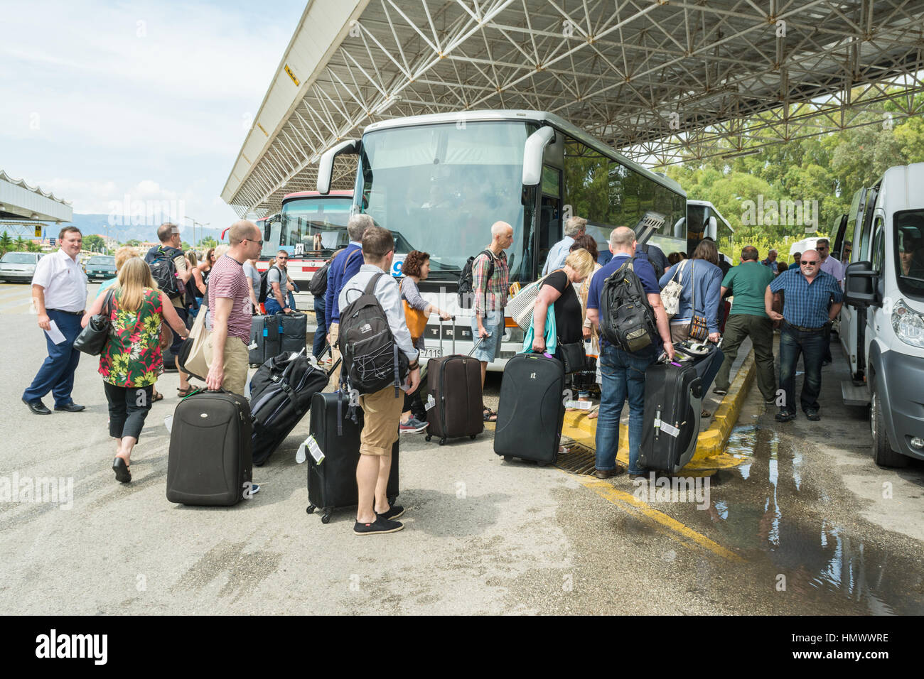 Pacchetto vacanze trasferimento aeroporto - i turisti con i bagagli di salire a bordo di un pullman a Corfu Airport per trasferimento per le loro vacanze e alloggi Foto Stock