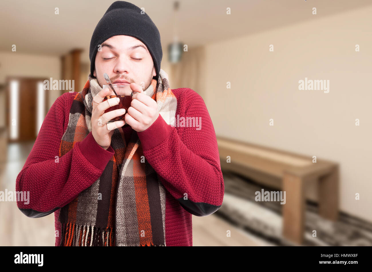Giovani malati maschio gustando il tè caldo nella stagione invernale all'interno della casa con copia spazio di testo Foto Stock