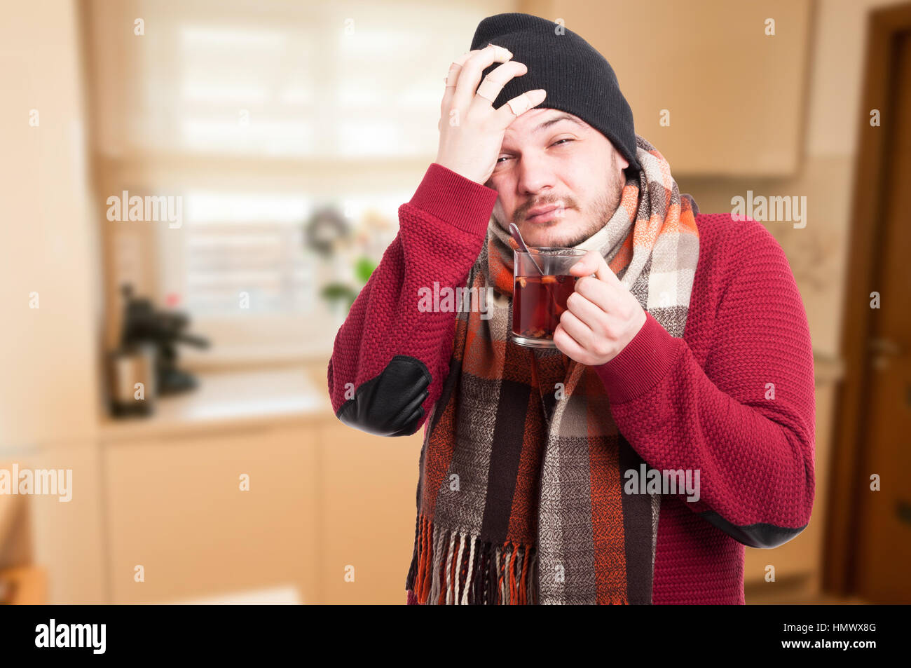 Uomo con influenza e febbre coppa di ritegno di guarigione il tè in casa con spazio di copia Foto Stock