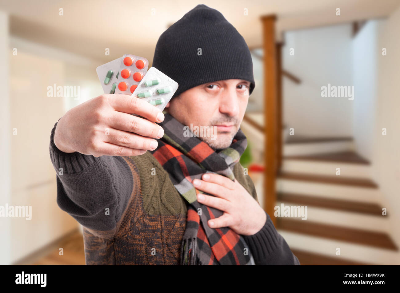 Giovani malati maschio con compresse in mano trattare la sua influenza Foto Stock