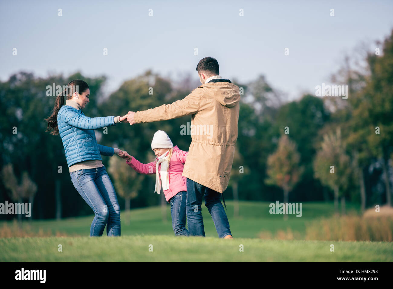 La famiglia felice tenendo le mani sul prato Foto Stock