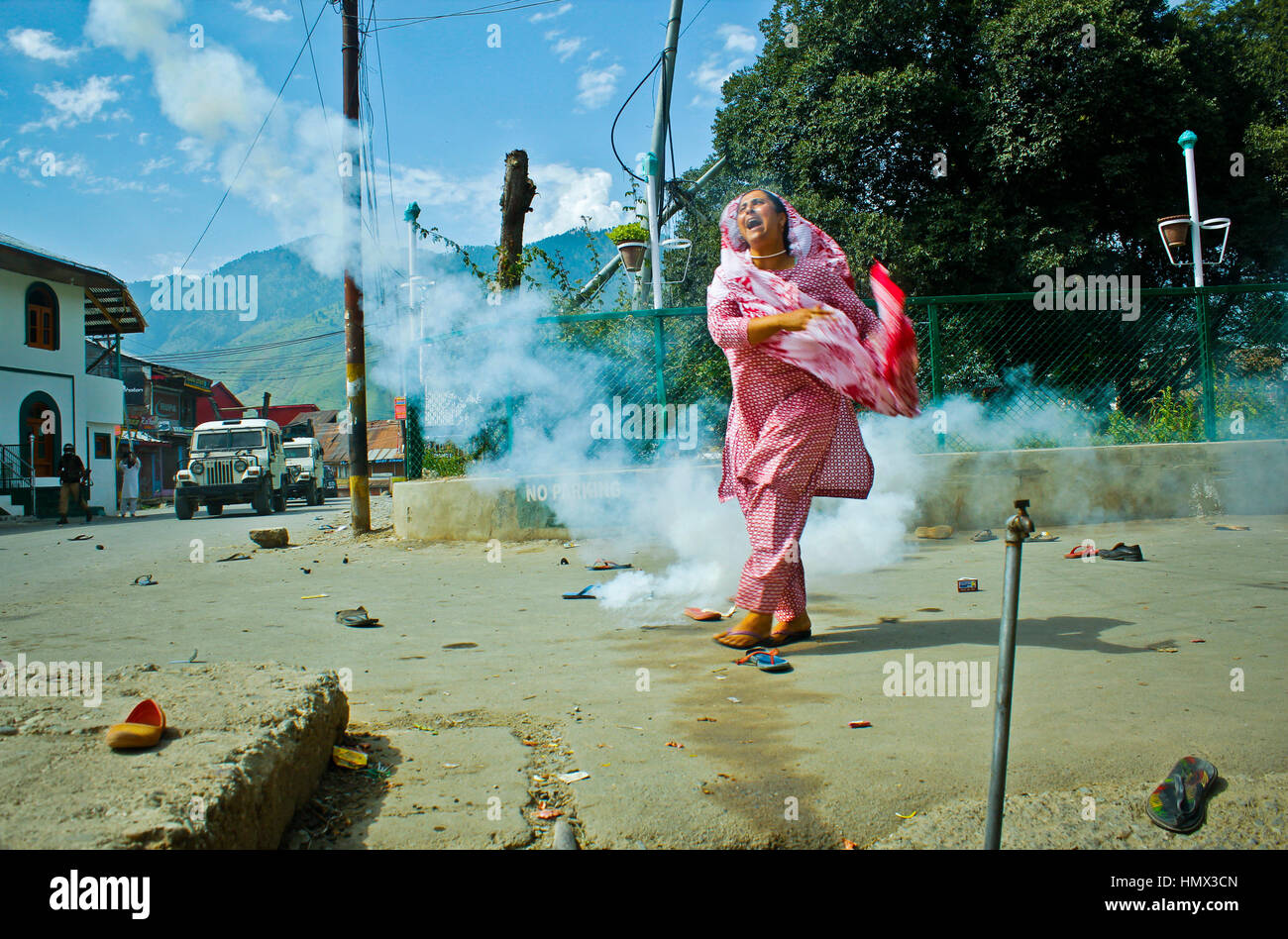 Insurrezione del Kashmir 2016: una donna getta uno strappo con un guscio di fumo torna a forze durante una manifestazione di protesta nel rally di Indiano-Kashmir amministrato il 19 agosto 2016. Foto Stock