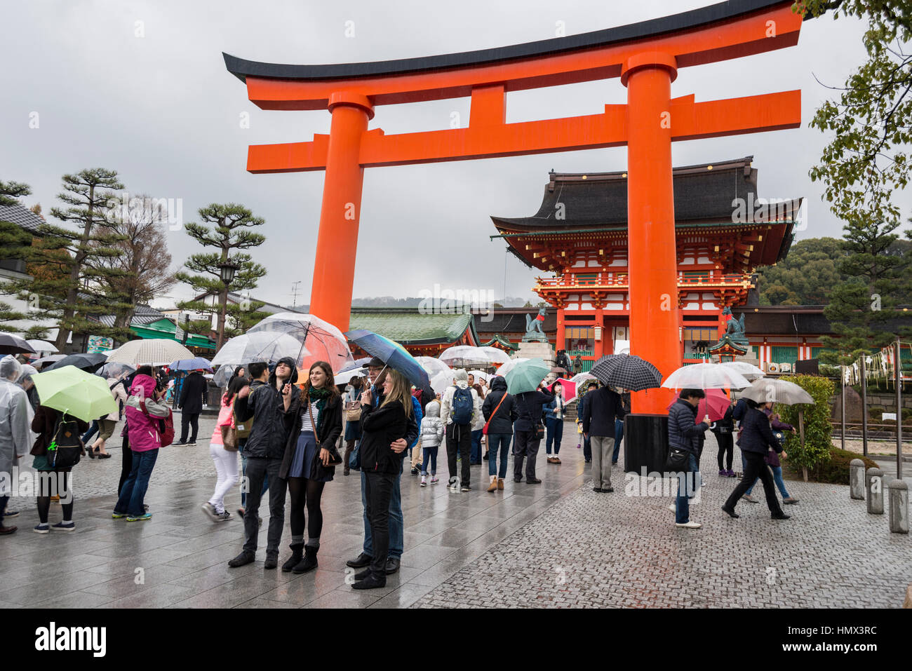 I turisti con ombrelloni in un giorno di pioggia a Fushimi Inari Taisha (sacrario scintoista), Kyoto, Giappone Foto Stock