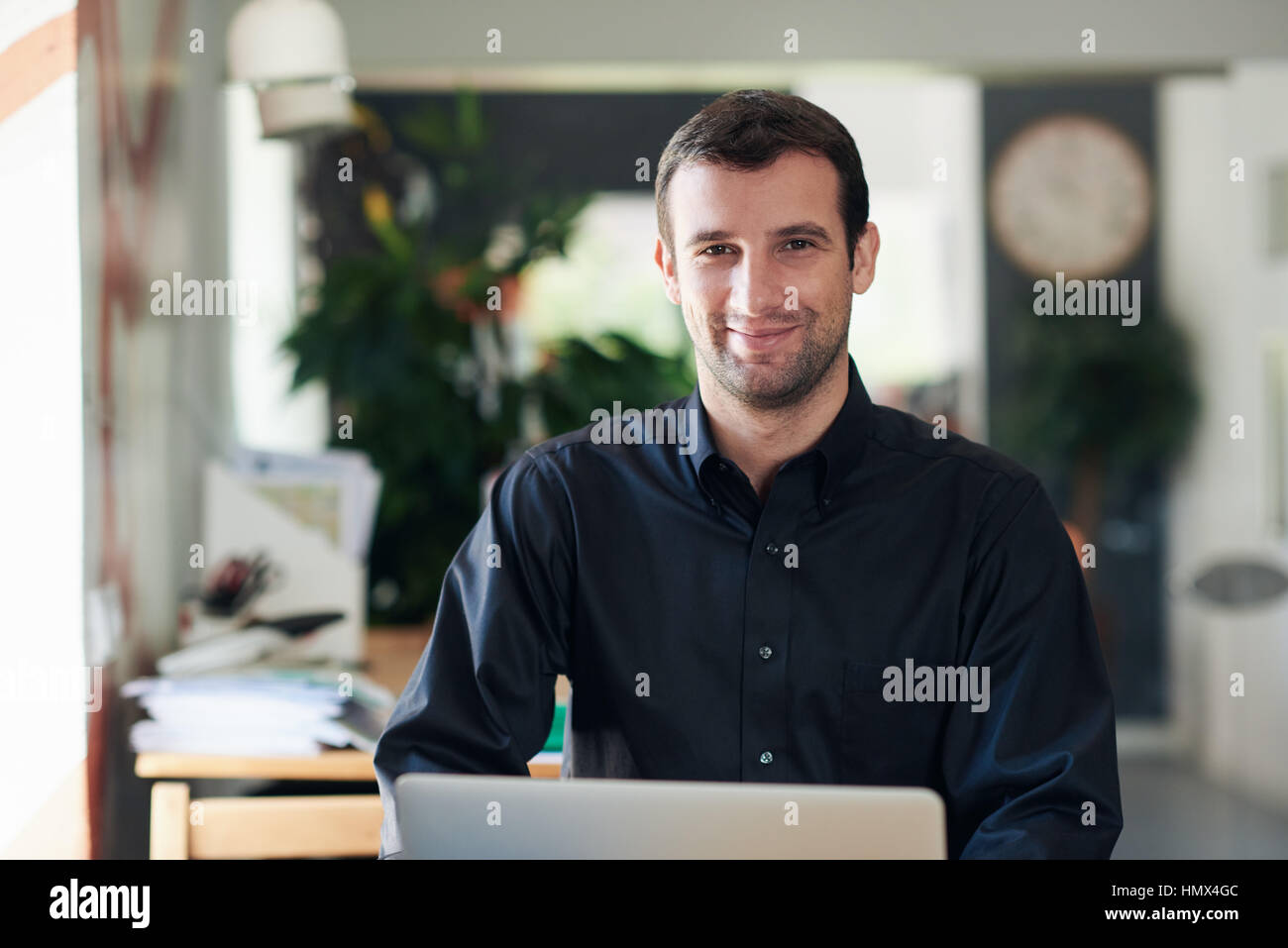 Imprenditore di successo e sorridente al lavoro su un notebook Foto Stock