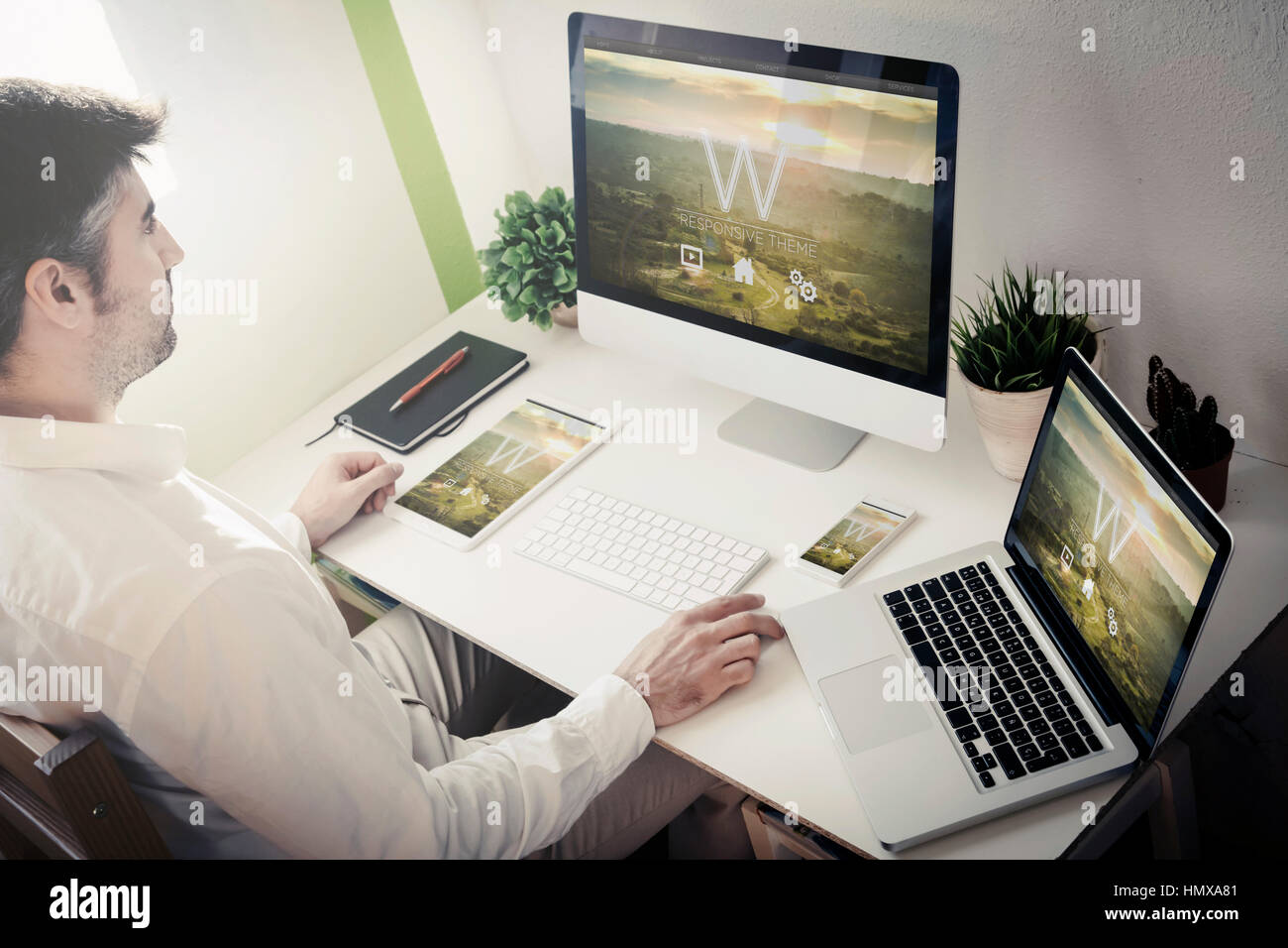 Uomo che lavora con i dispositivi con tema sensibile sito web. Tutti i grafici dello schermo sono costituiti. Foto Stock