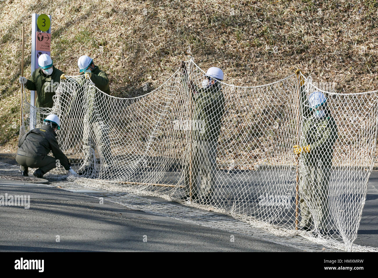 Tokyo, Giappone. 7 febbraio, 2017. I custodi del giardino zoologico tenere premuto su una rete in un tentativo di catturare un scimpanzé sfuggito durante un animale sfuggito trapano a Tama Zoological Park il 7 febbraio 2017 a Tokyo, in Giappone. La fuga annuale trapano è tenuto a Tokyo i giardini zoologici per i custodi del giardino zoologico di pratica come avrebbero bisogno di reagire in caso di una catastrofe naturale o un'altra emergenza. Questo anno un membro del personale che indossa un costume di scimpanzé è stata catturata e sottomessa da altri i custodi del giardino zoologico prima che potesse sfuggire per le strade di Tokyo. Credito: Aflo Co. Ltd./Alamy Live News Foto Stock