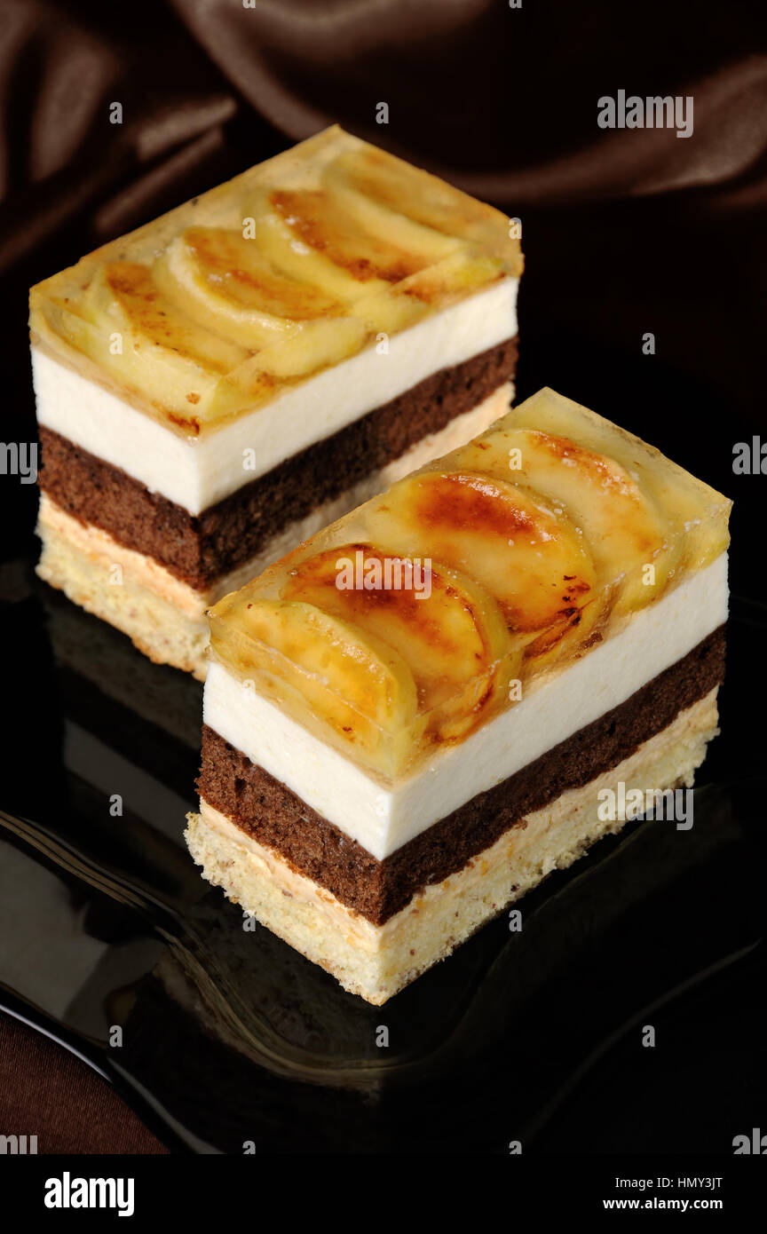 Torta impilati dal caramello, Apple, mousse di cioccolato e mandorle biscotto con uno strato di gelatina di fette di mela caramellate Foto Stock