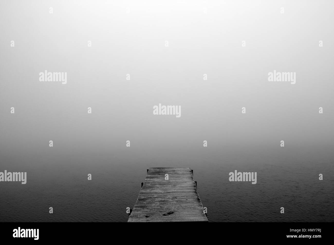 Il ponte che si estendono nel lago nebbioso Foto Stock