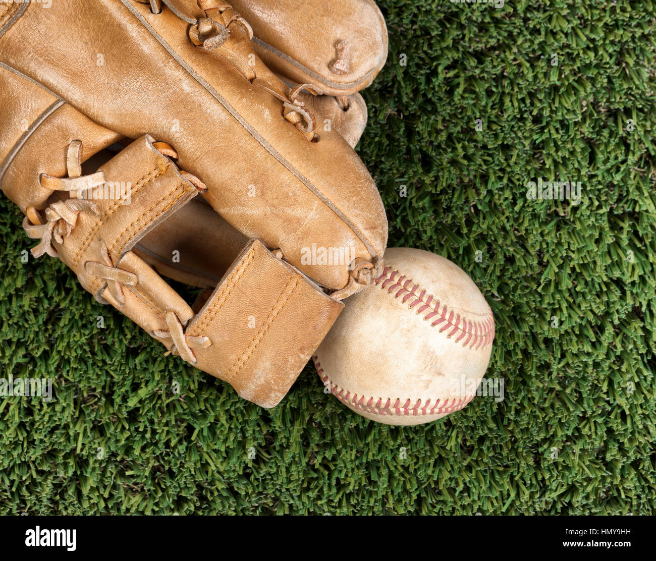 Vista piana della vecchia guanto da baseball e utilizzati e a sfera sulla superficie di erba Foto Stock