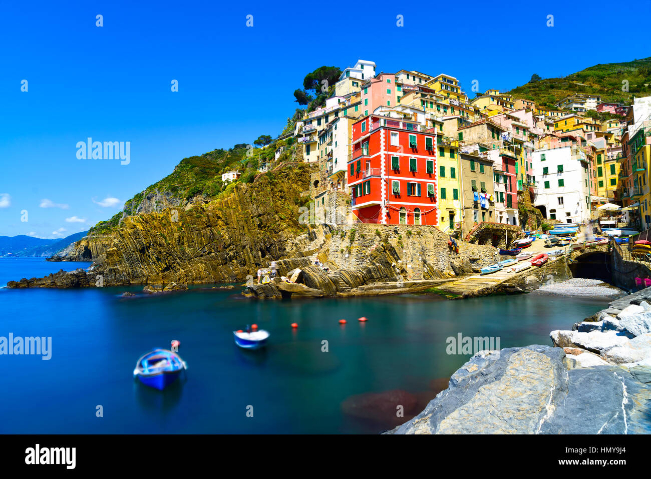 Riomaggiore villaggio sulla scogliera di rocce e mare al tramonto., Seascape in cinque terre, il Parco Nazionale delle Cinque Terre Liguria Italia Europa. Esposizione lunga Foto Stock